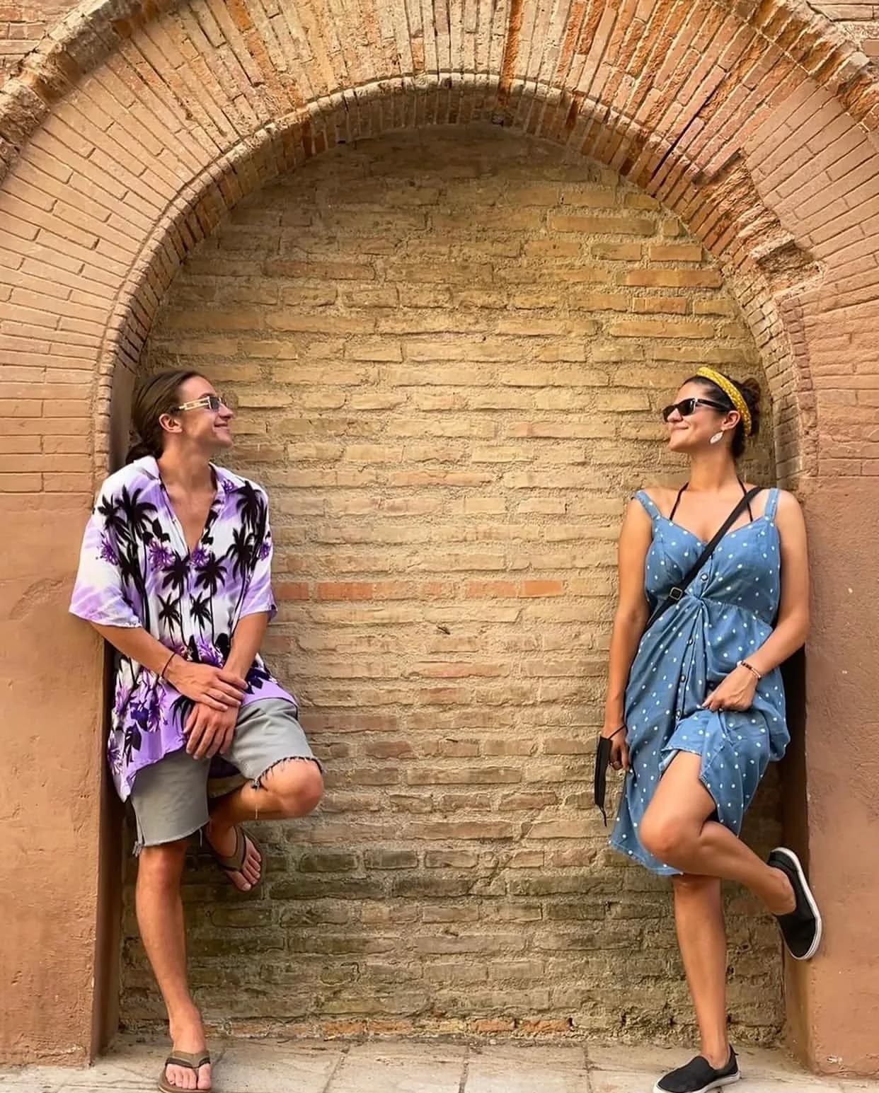 Lithi founders Ollie Hawkins and Annette smiling at each other beneath a brick arch.